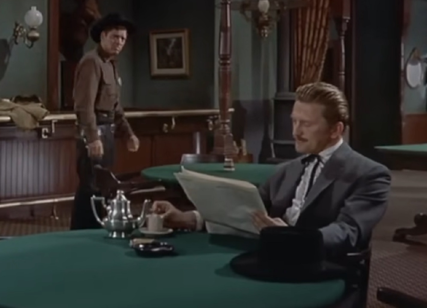 Screenshot of Kirk Douglas reading a newspaper at saloon - from Gunfight at the O.K. Corral (1957)