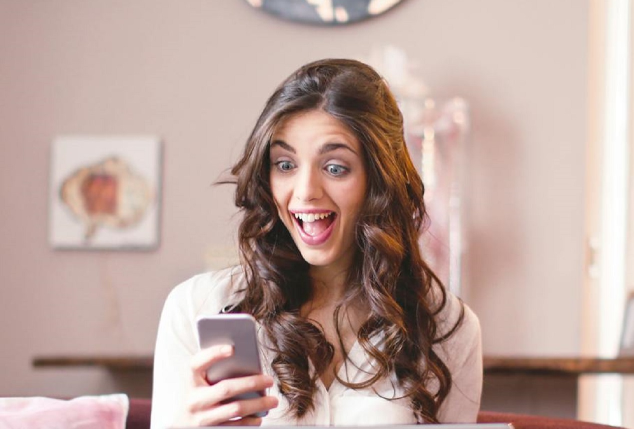 Surprised woman looking at cell phone