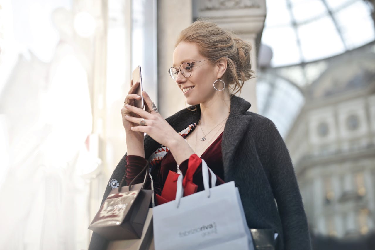 Woman Standing Near Glass Holding Phone