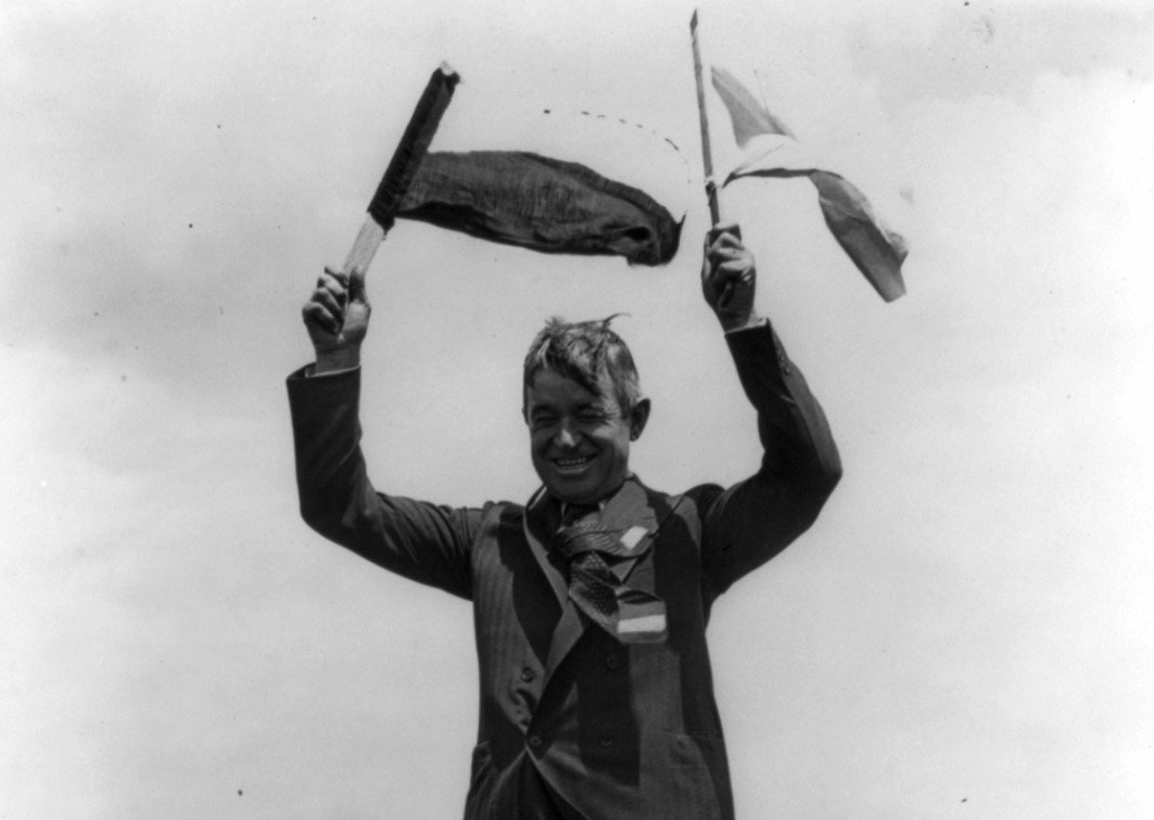 Will Rogers holding flags