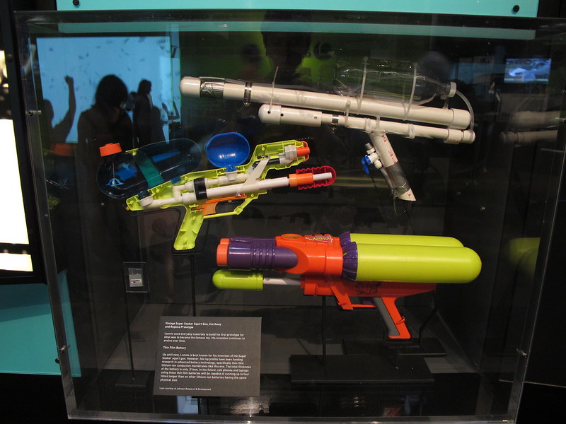 Close Up Photo of Vintage Super Soaker Squirt Gun Cut Away and Replica Prototype. Dark background.