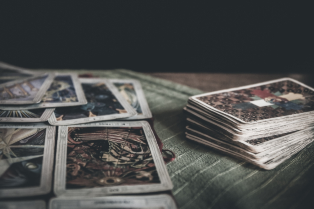 mystic tarot deck and old tarot cards laying on table