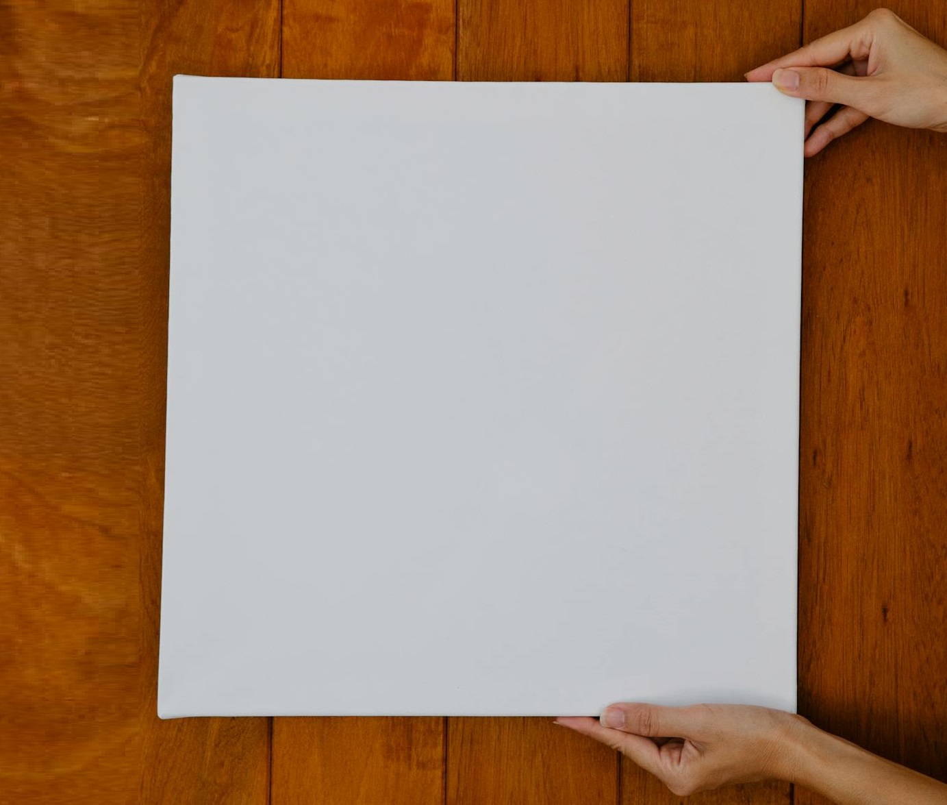 Crop unrecognizable woman demonstrating blank canvas