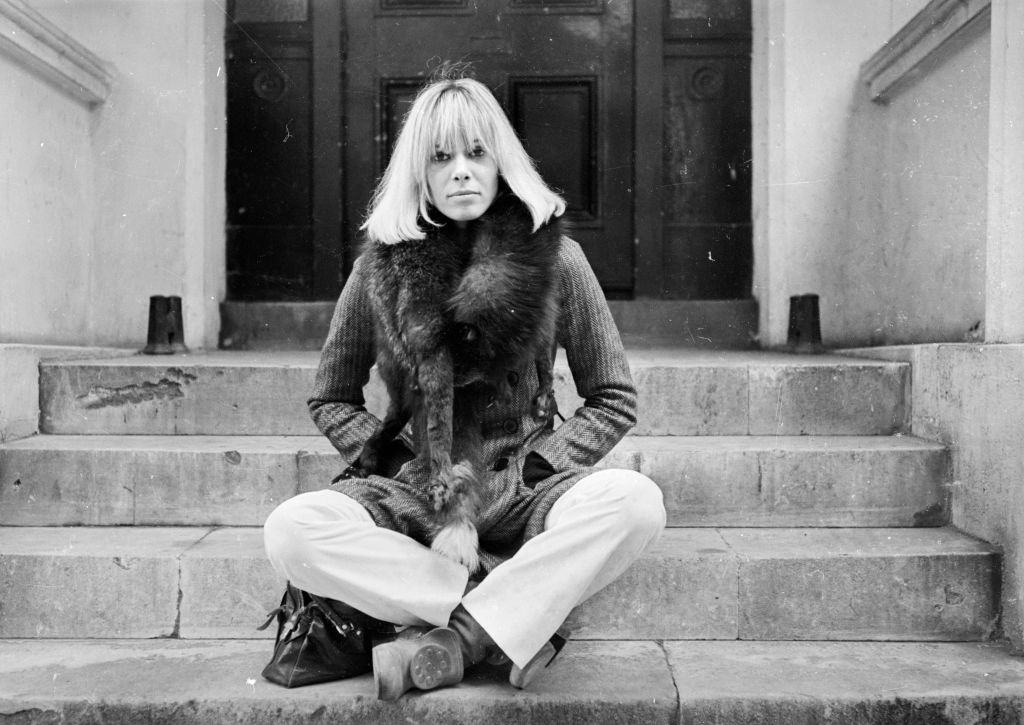 Anita Pallenberg sits cross-legged
