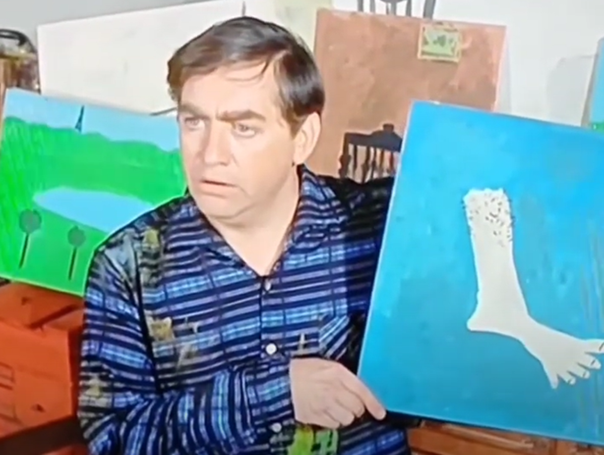 Screenshot of Tony Hancock holding an image - from The Rebel (1961)