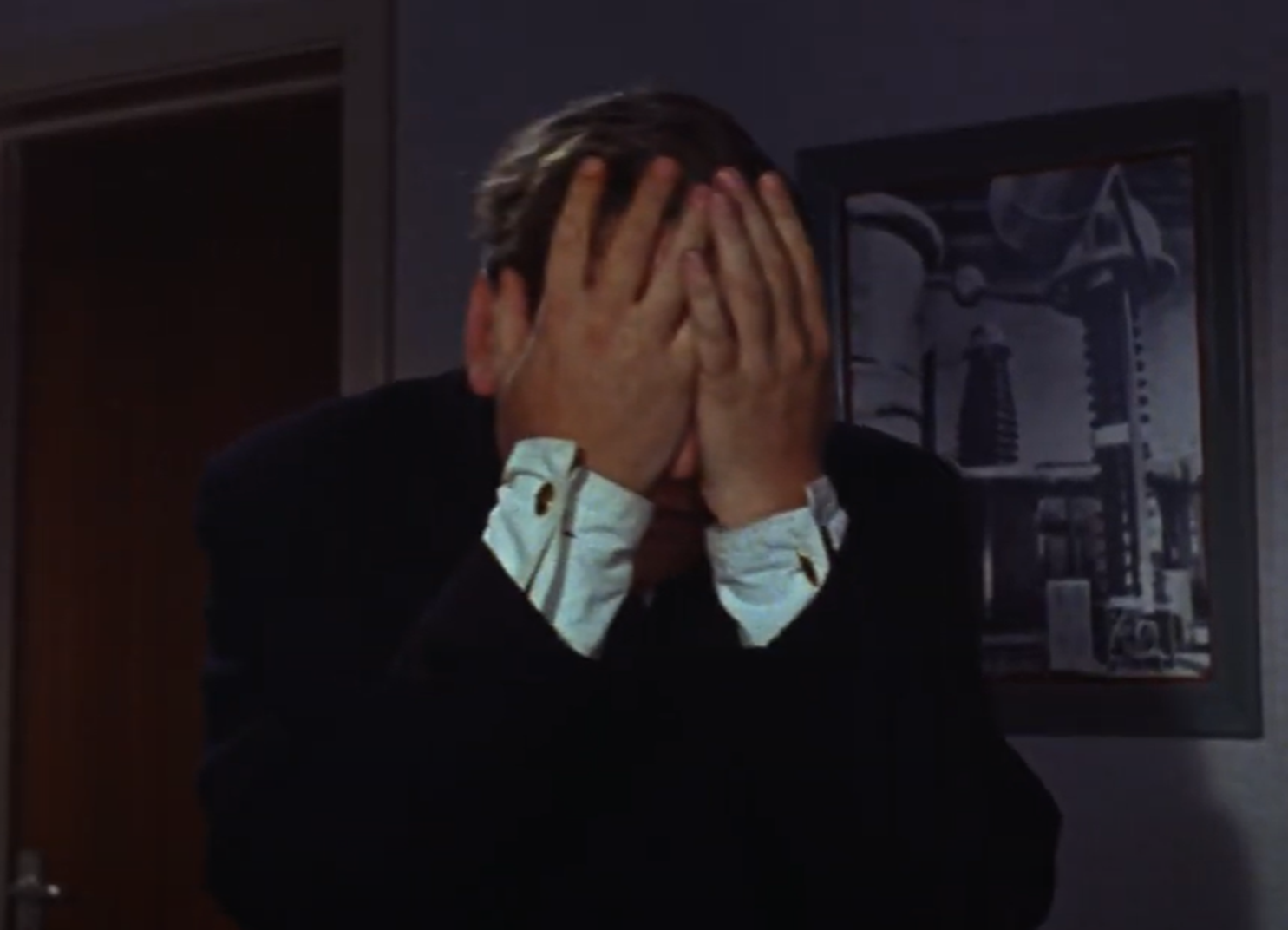 Screenshot of Tony Hancock covering his face - from The Rebel (1961)