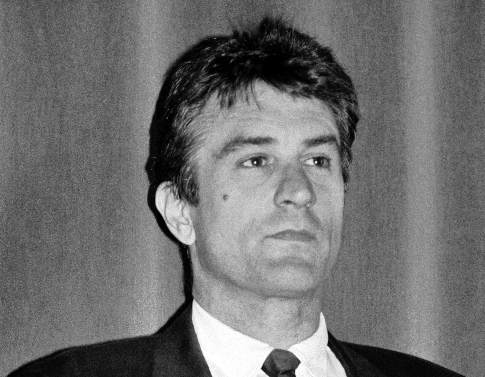 Robert De Niro looking at side in black suit - 1988