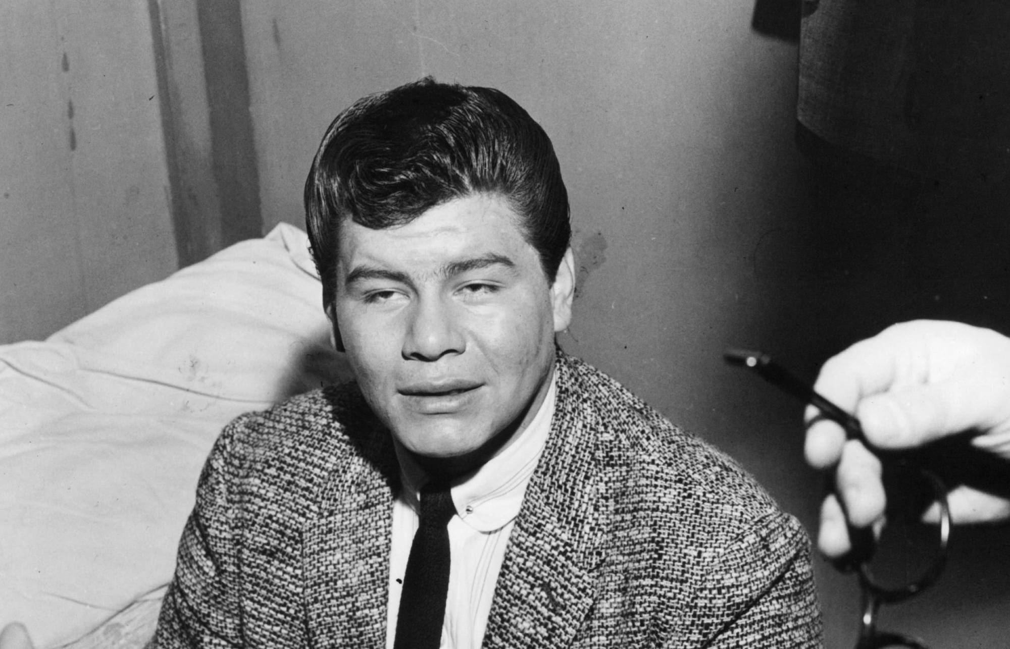 Ritchie Valens sits on bed in a scene from the film 'Go, Johnny, Go!', 1959.