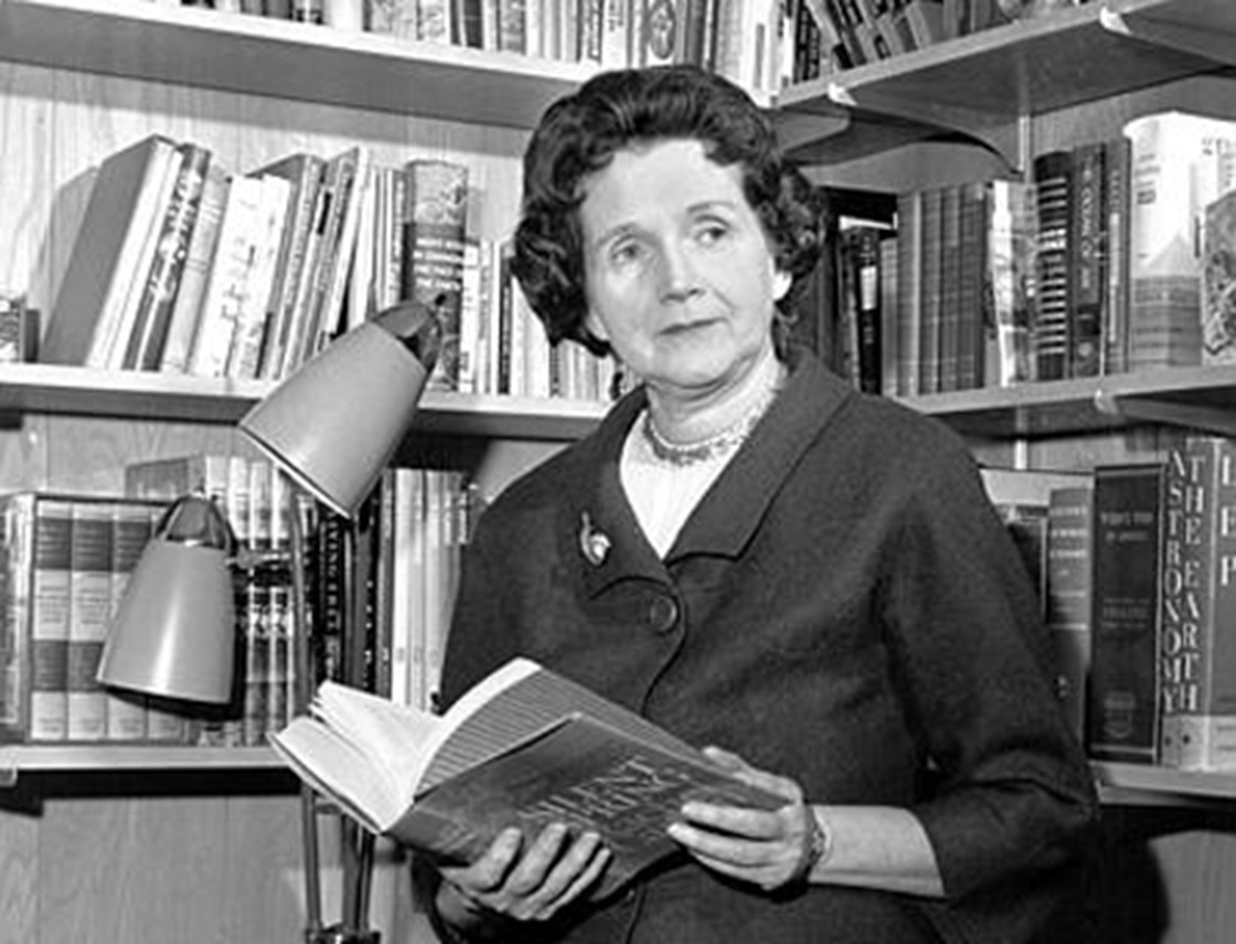 Rachel Carson holding a book and looking at side.