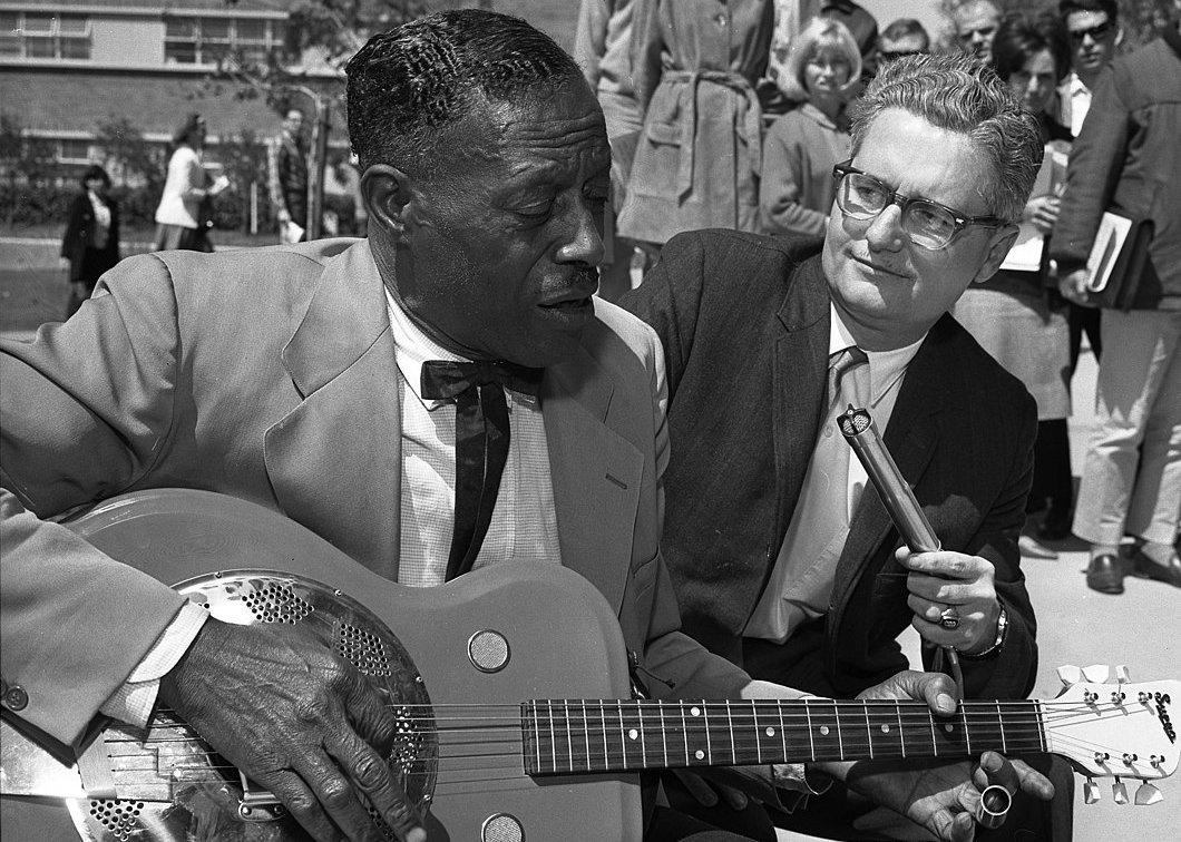 Blues guitarist Son House playing on his guitar and singing playing