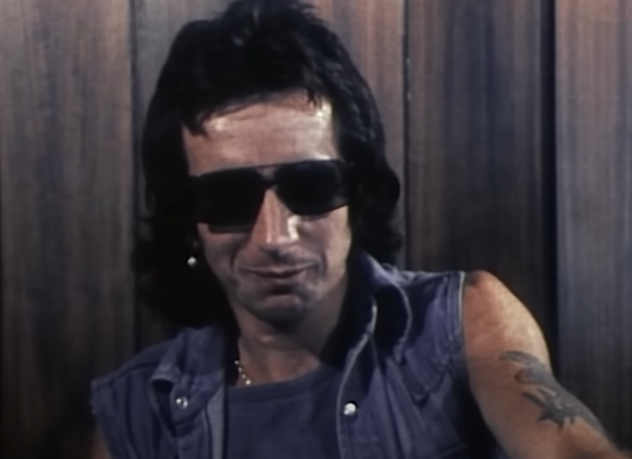 Screenshot of Bonn Scott talking at camera from - On The Brink (2022)