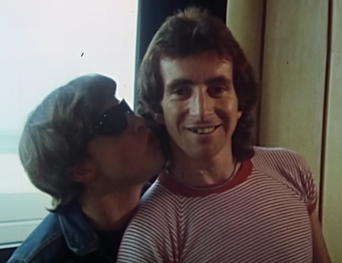 Screenshot of Bonn Scott smiling at camera from - On The Brink (2022)