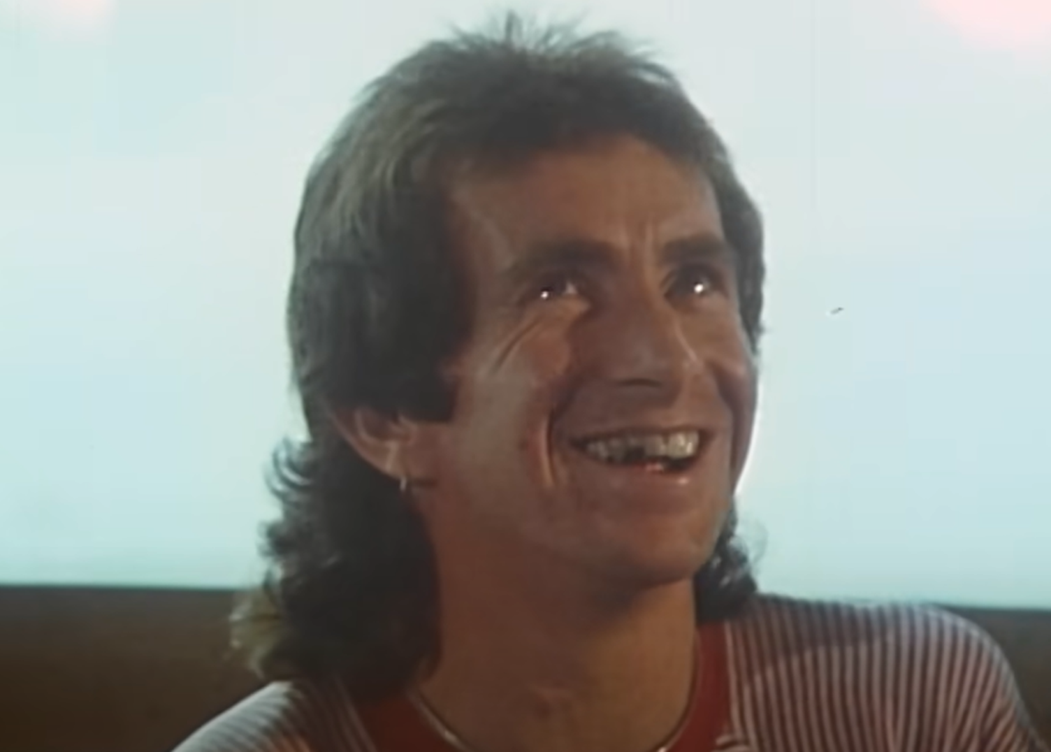 Screenshot of Bonn Scott smiling at camera from - On The Brink (2022)