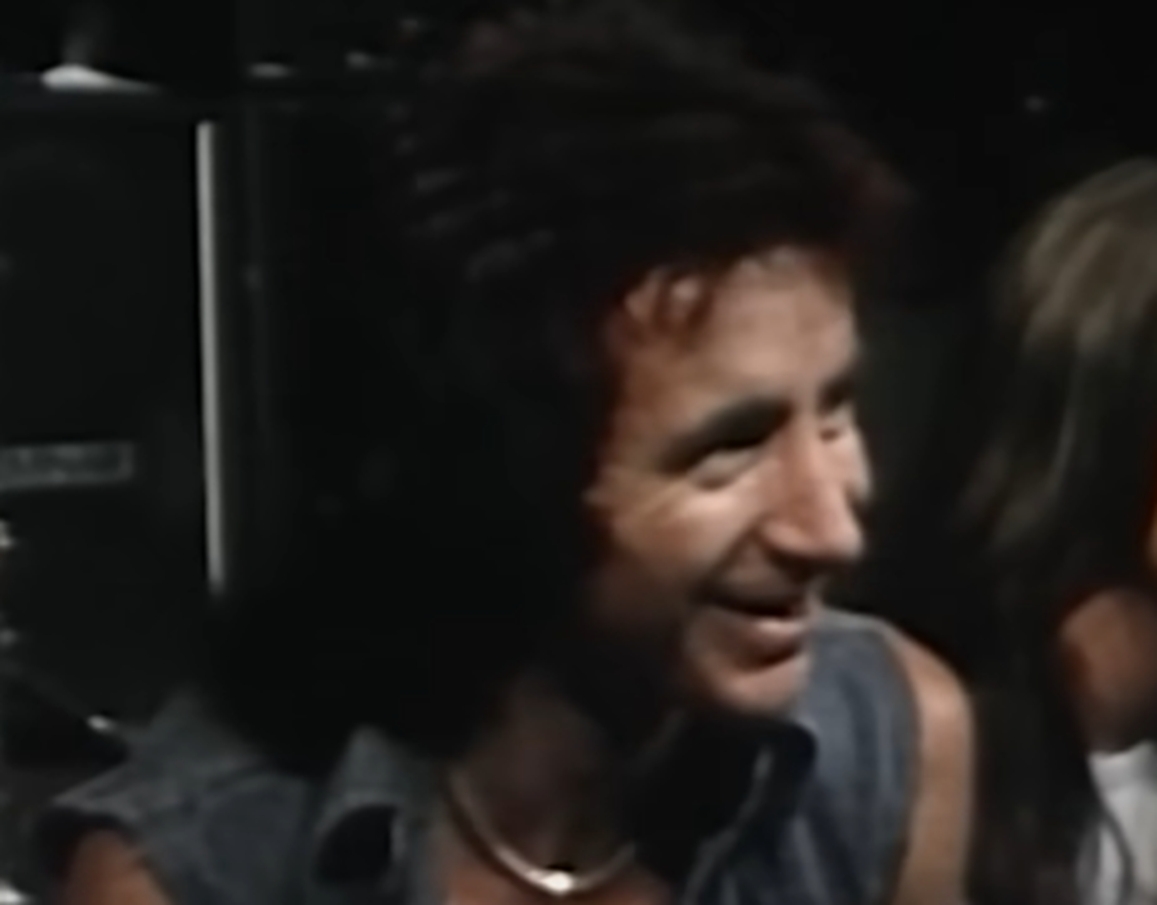 Screenshot of Bonn Scott smiling at camera from - On The Brink (2022)