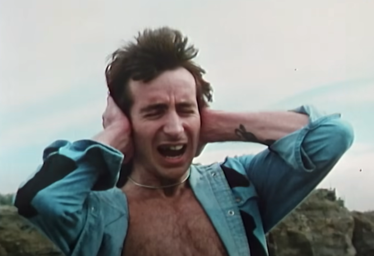 Screenshot of Bonn Scott holding his head from - On The Brink (2022)