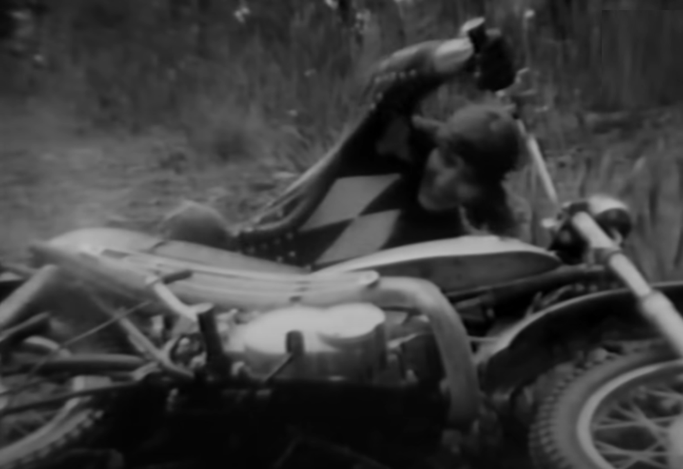 Screenshot of Bonn Scott looking down on his bike from - On The Brink (2022)