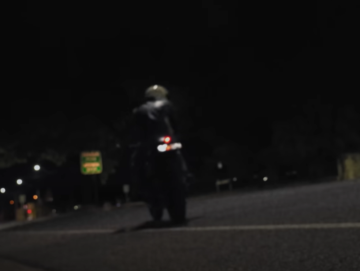 Screenshot of Bonn Scott looking down on his bike from - On The Brink (2022)