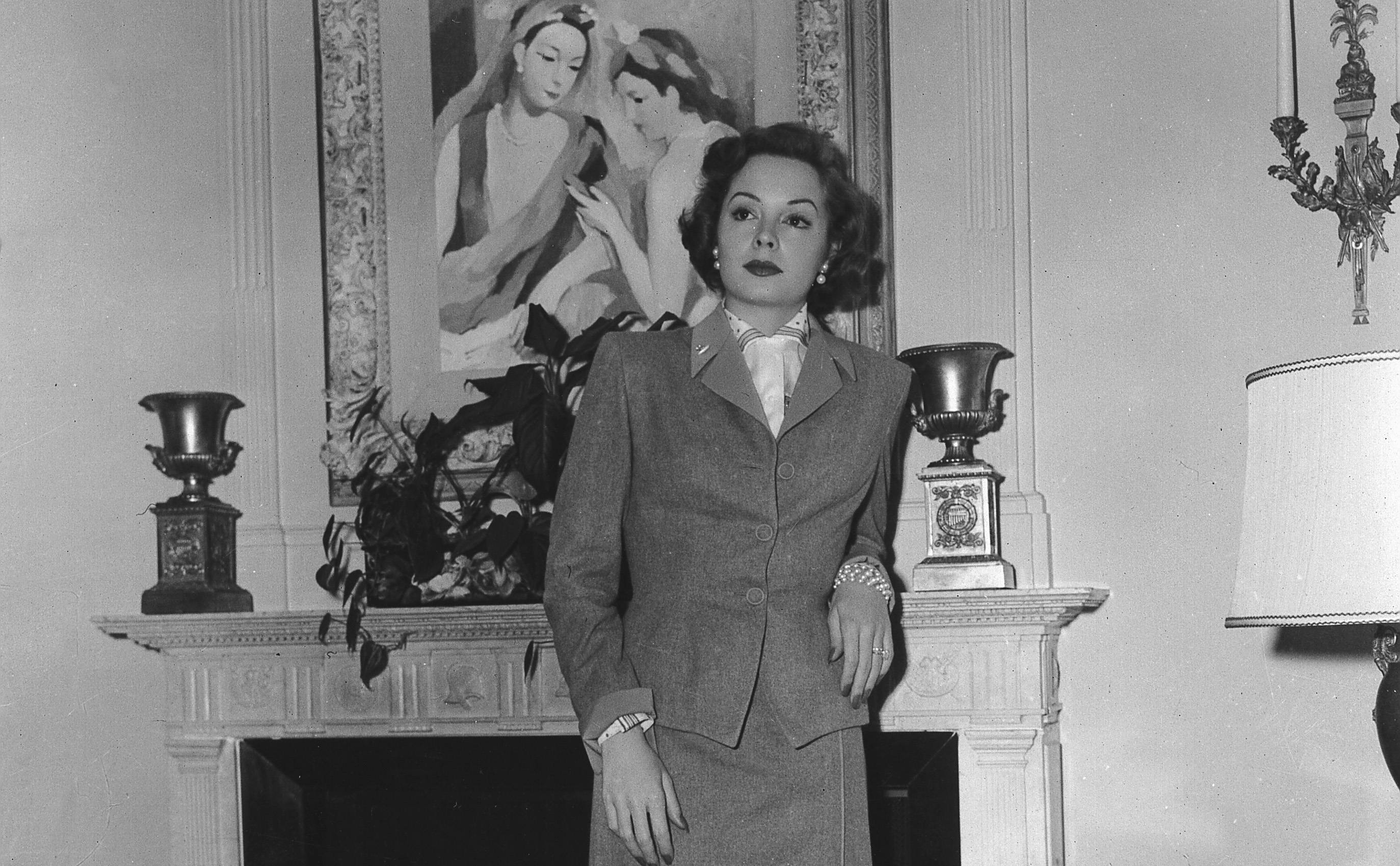 Portrait of Jane Greer in front of a fireplace