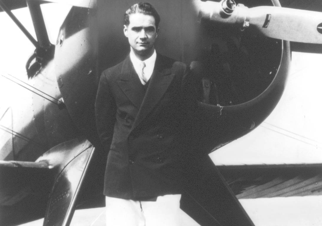 A portrait of Howard Hughes in front of his new plane