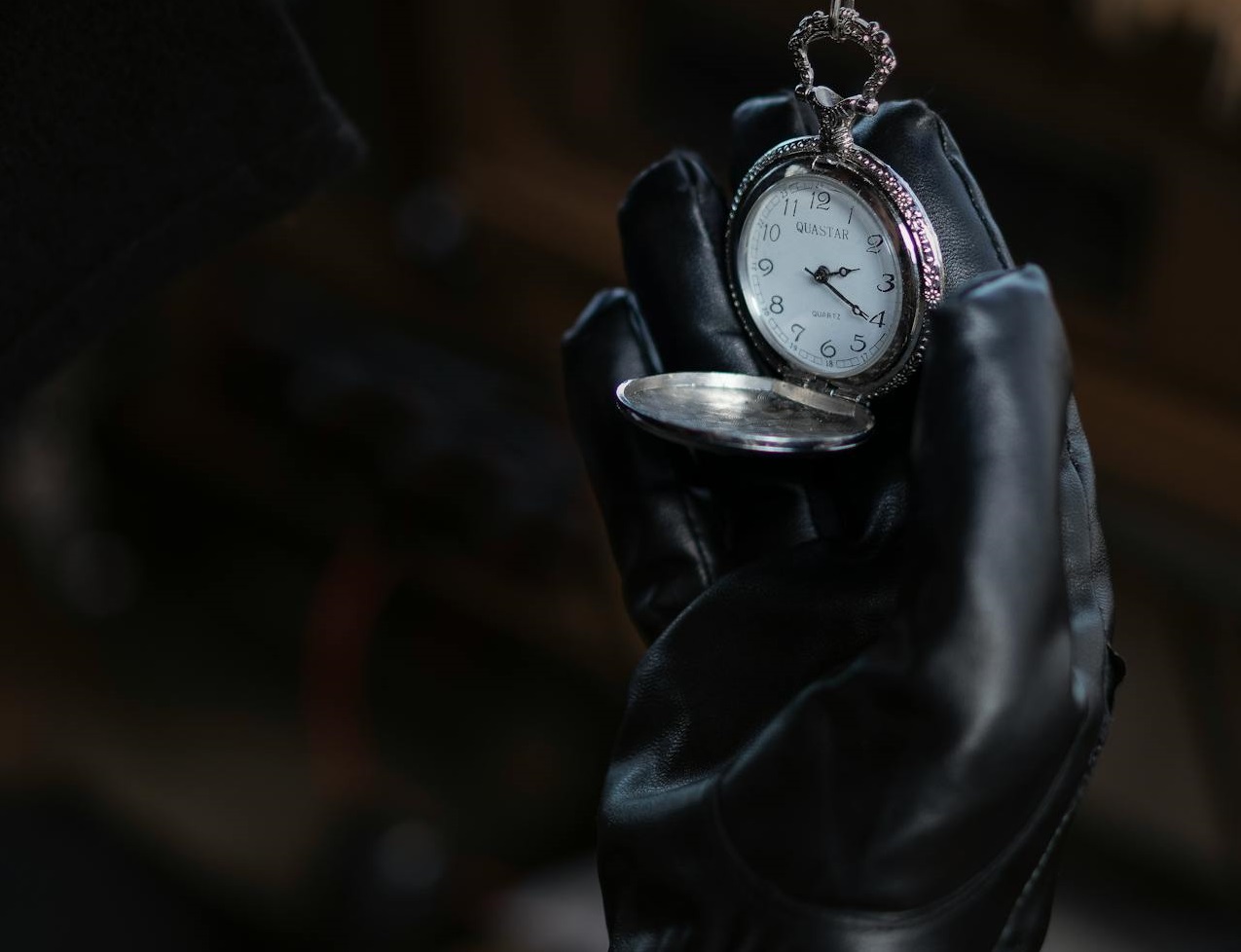 Man in leather gloves showing vintage pocket watch