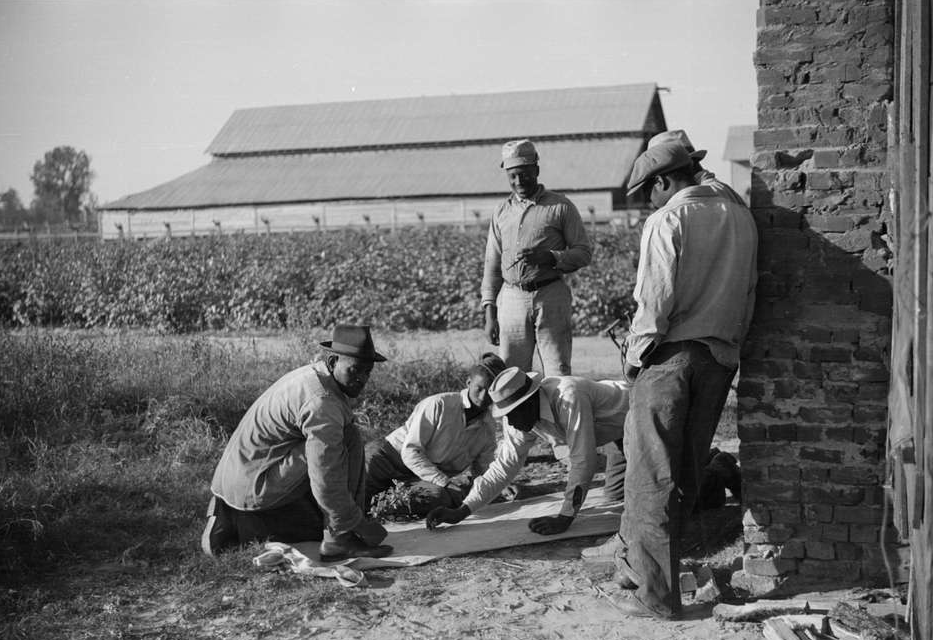 A group of men working on a piece of wood