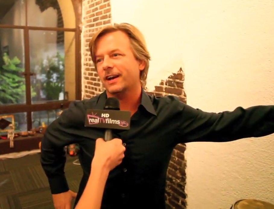 Comedian David Spade speaking to a reporter