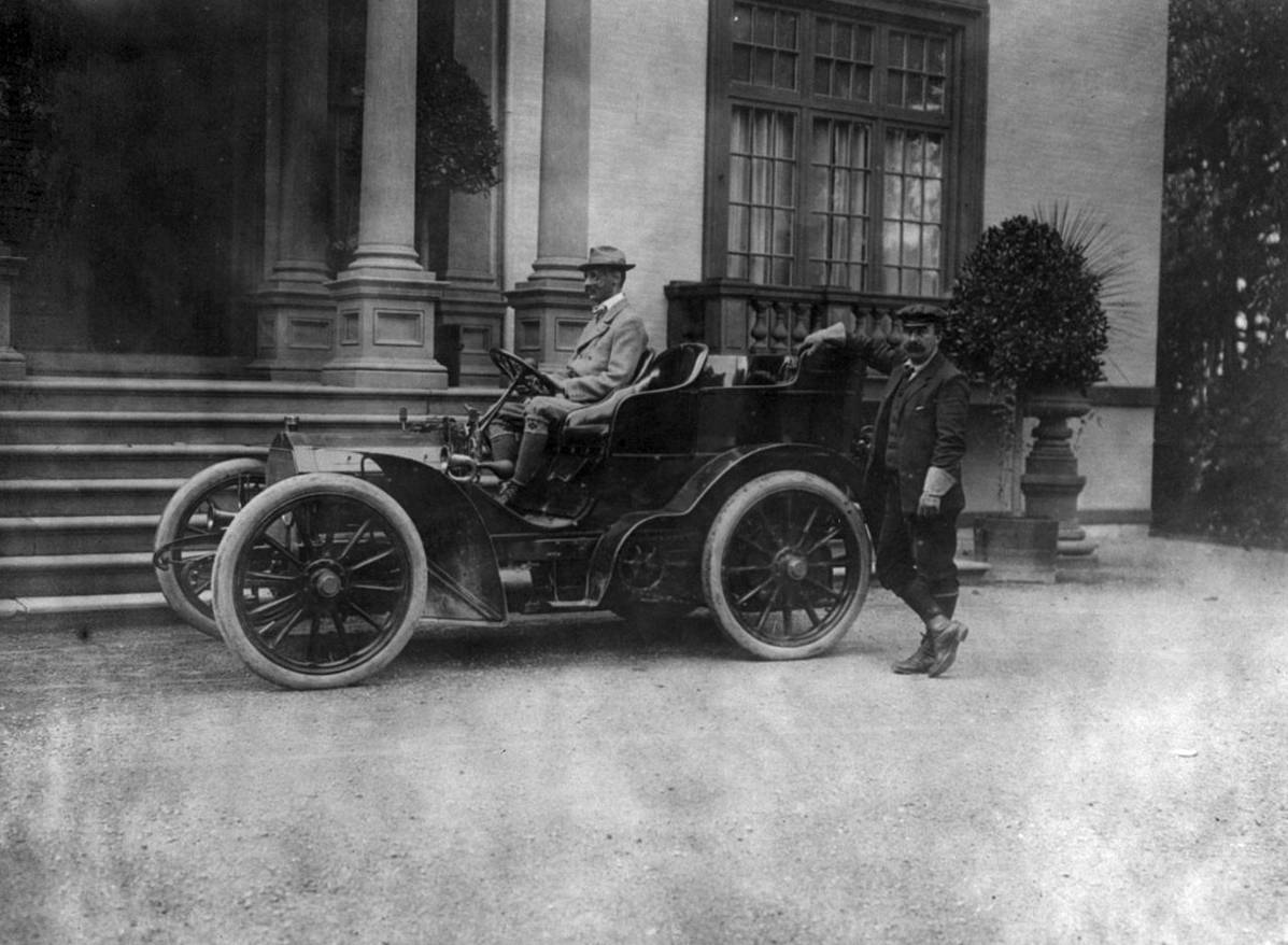 John Jacob Astor IV wearing a suit, sitting in a car