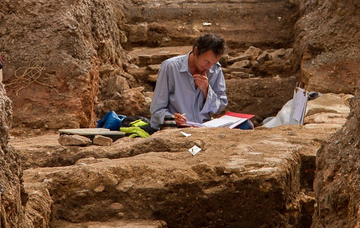 Archaeologist Working In Trench