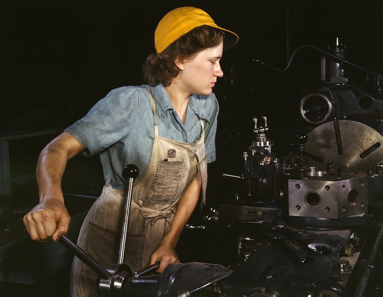 A female worker works with a metal lathe in a machine shop - 1942