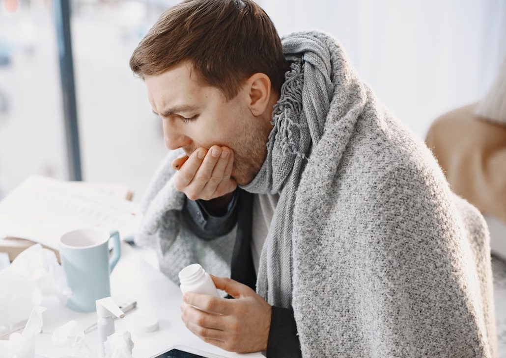 A Sick Man Covering His Mouth