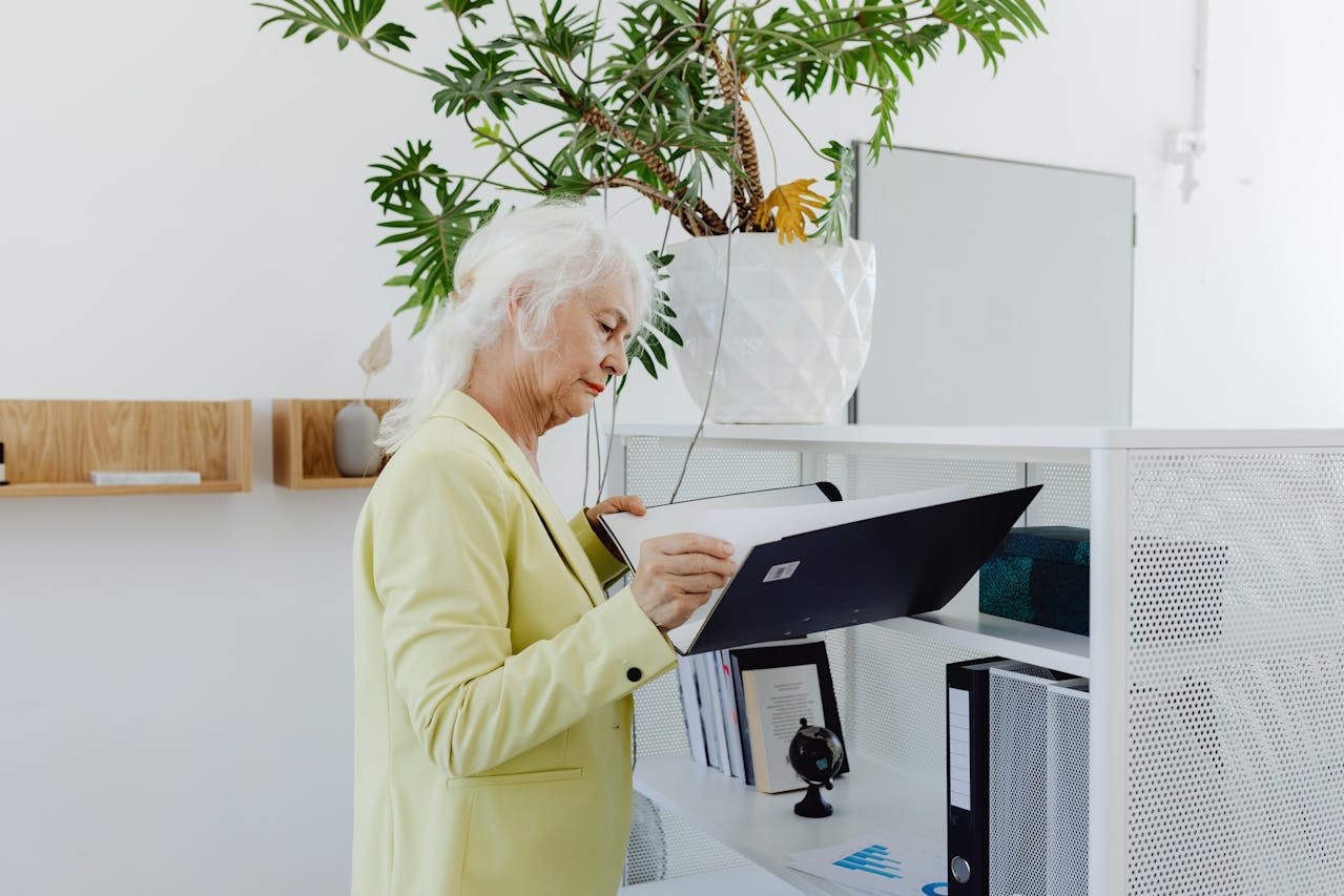 Elderly Woman Holding a Binder at office.