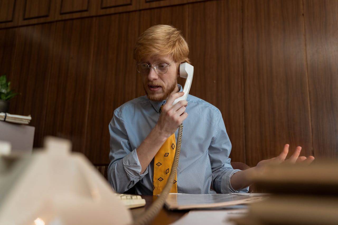 A Man Talking on the Telephone in his office.