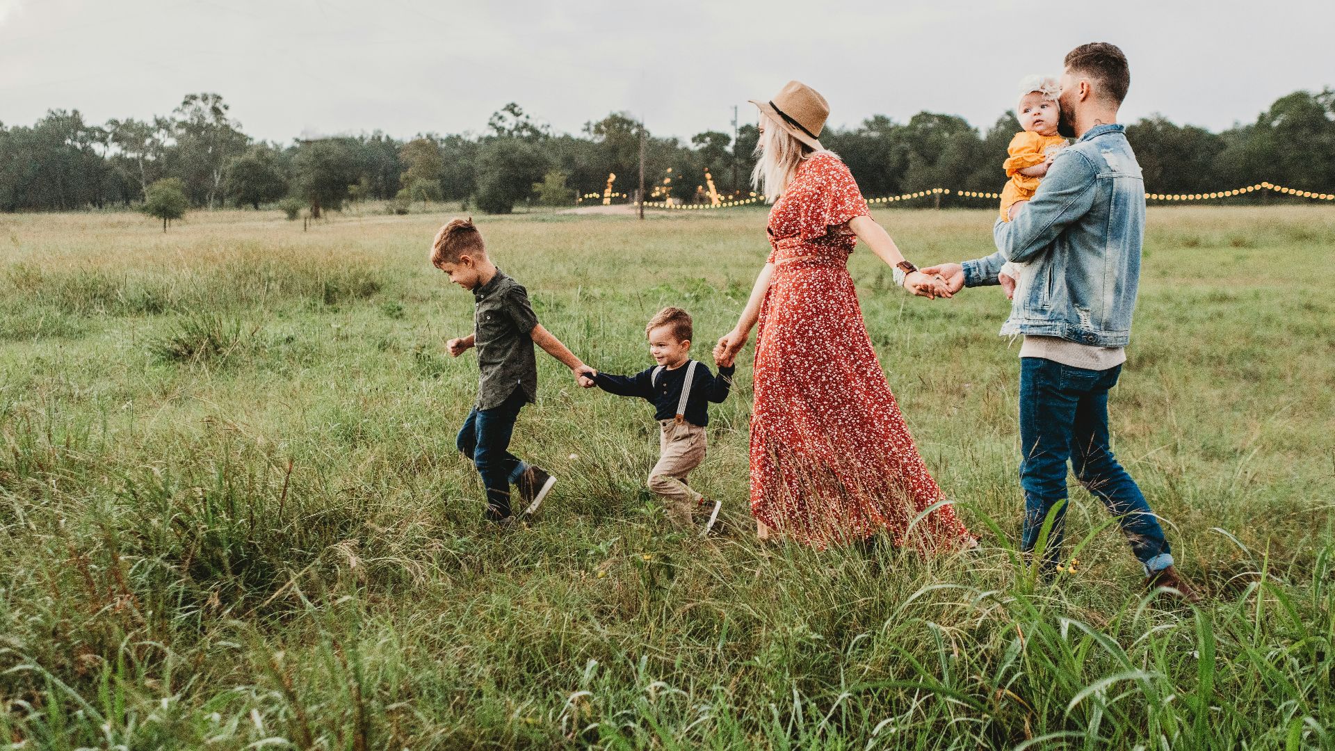 woman holding man and toddler hands during daytime
