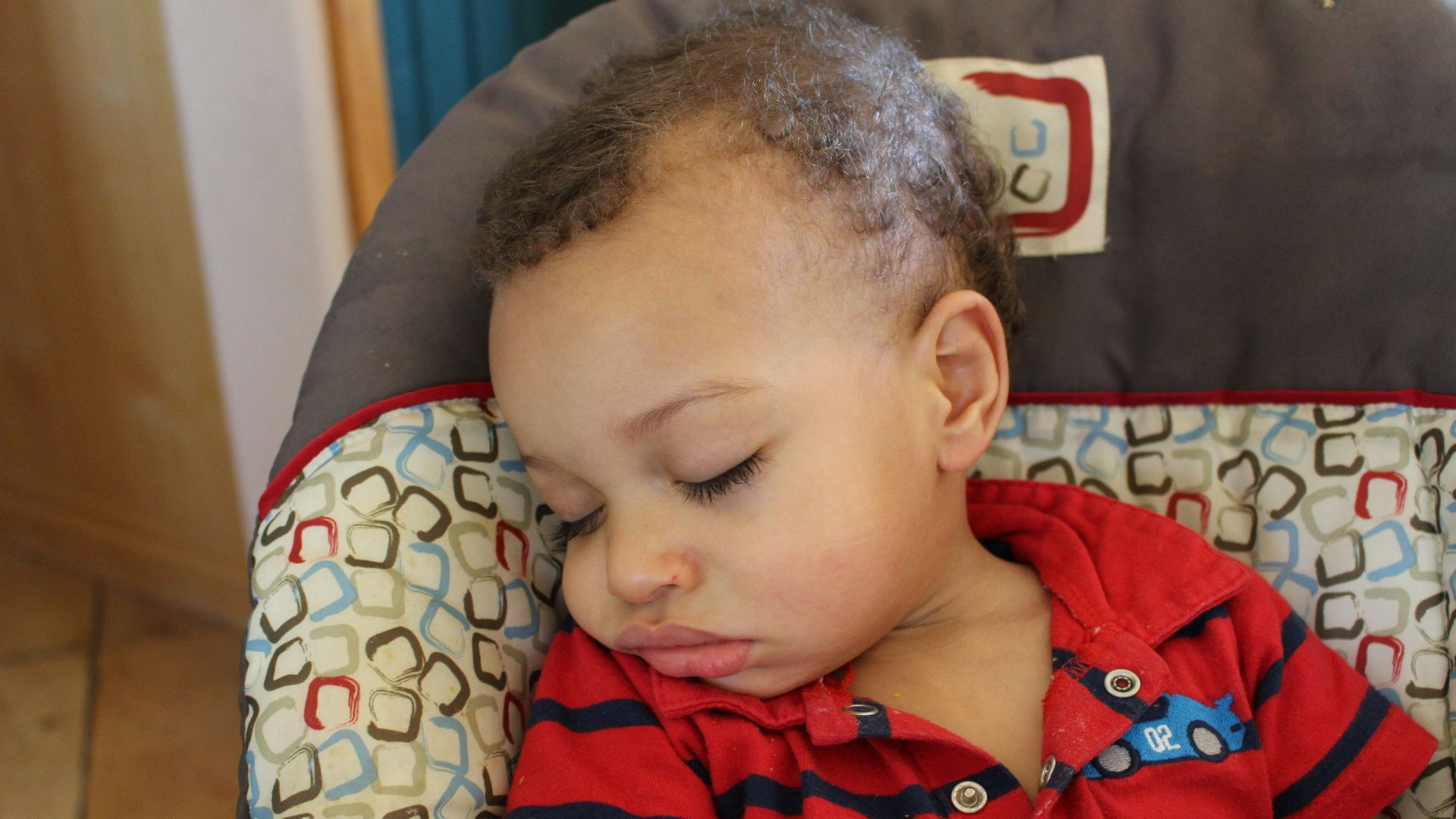 boy in red and white stripe polo shirt