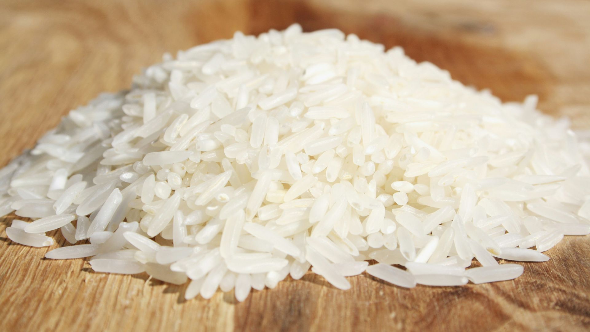 A pile of rice sitting on top of a wooden cutting board