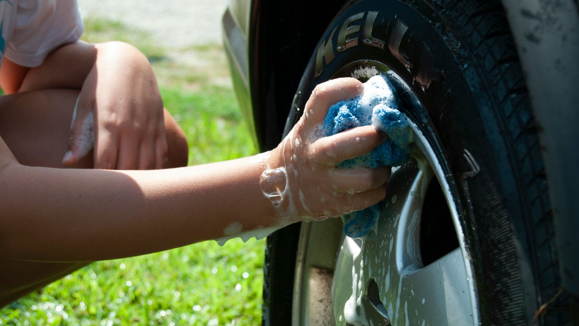 person washing vehicle tire