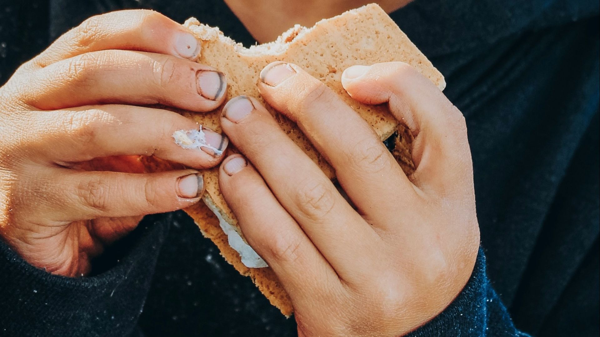 boy in black and white sweater holding brown leaf