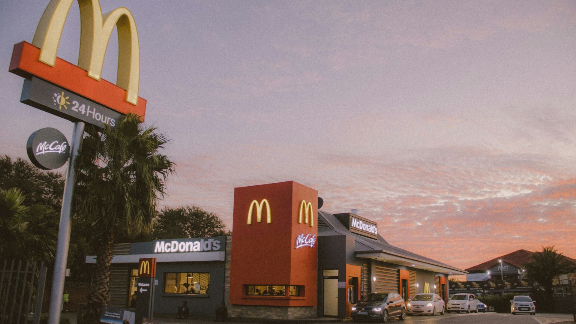 red and white concrete building near palm trees during daytime