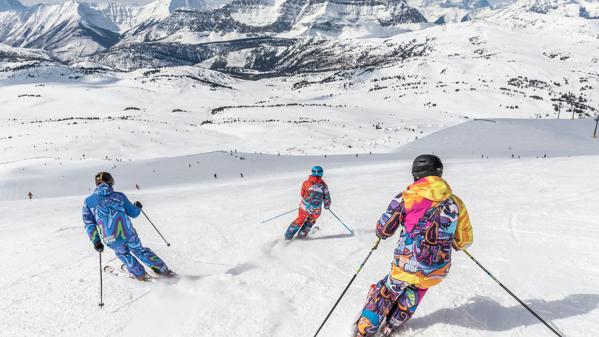 2 person in yellow jacket and blue helmet riding ski blades on snow covered mountain during
