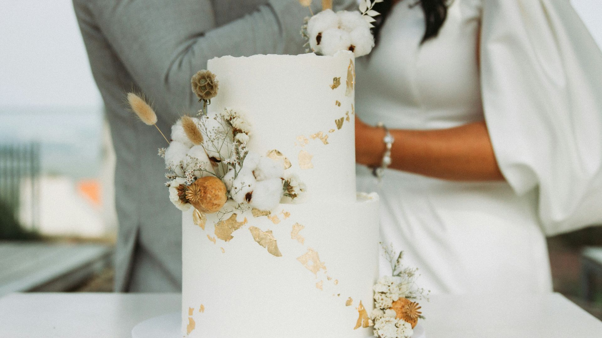 a newly married couple cutting their wedding cake