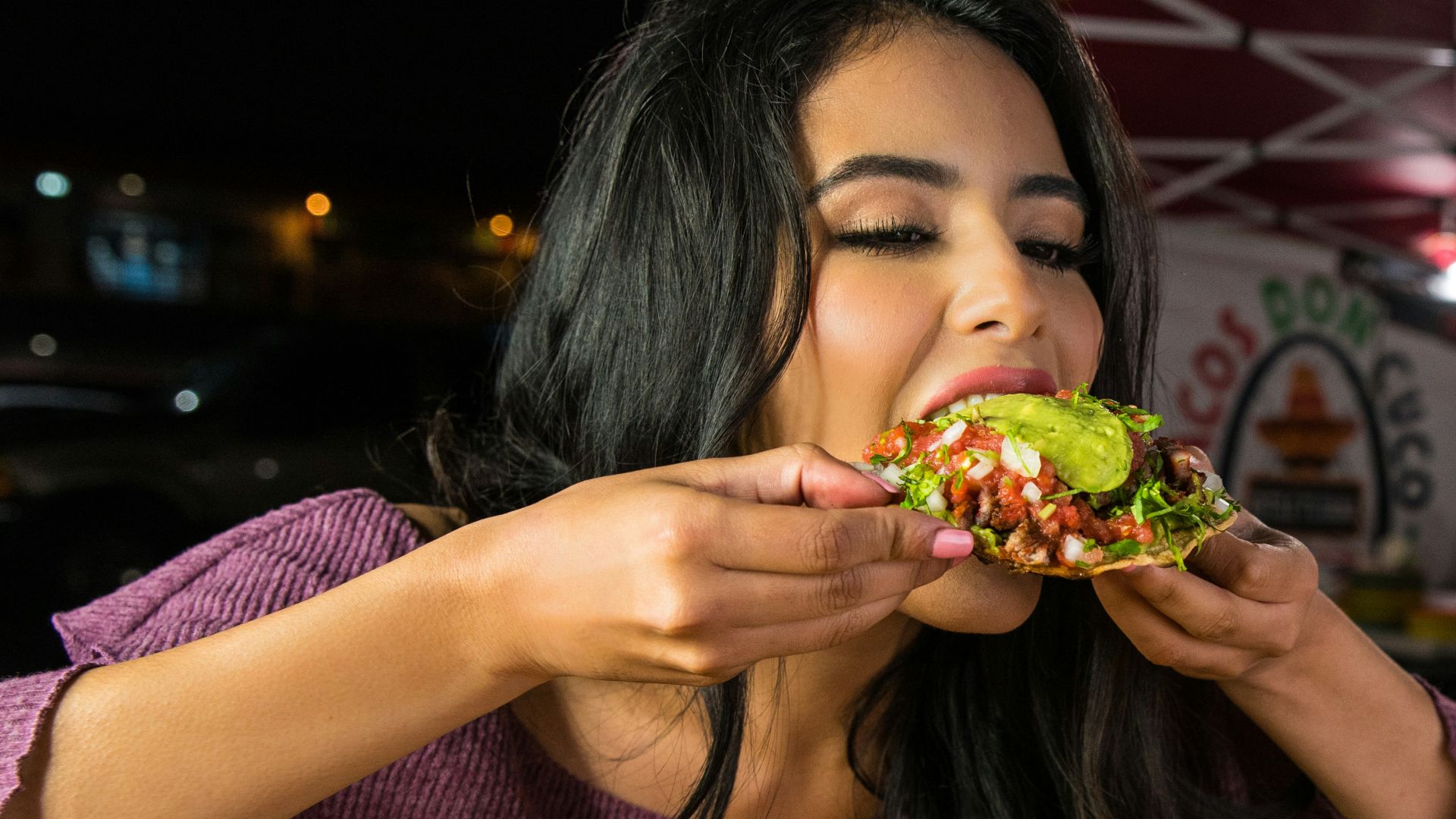 woman in purple shirt holding green and yellow floral ceramic bowl