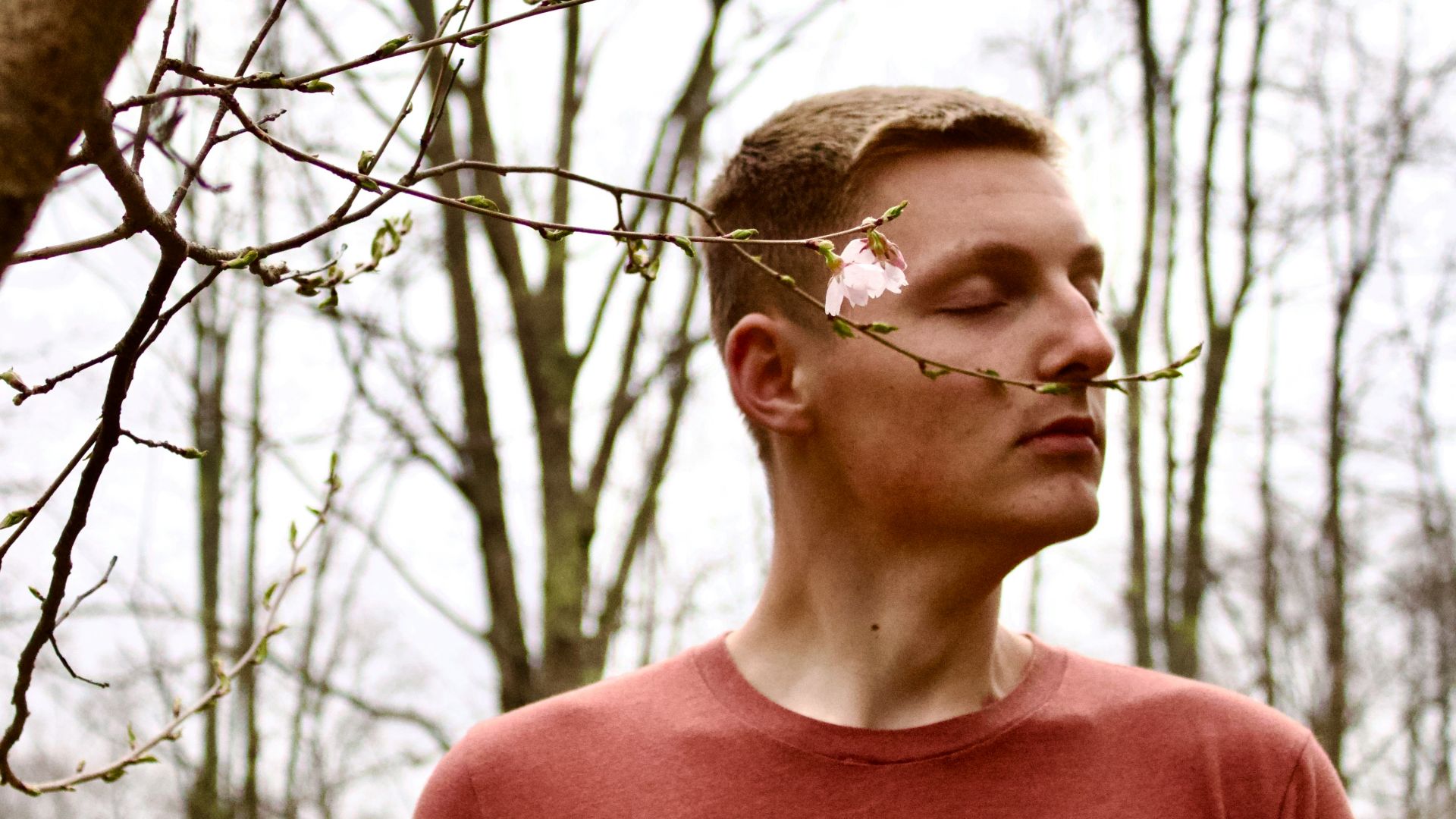 a man standing in front of a tree with a bicycle on it