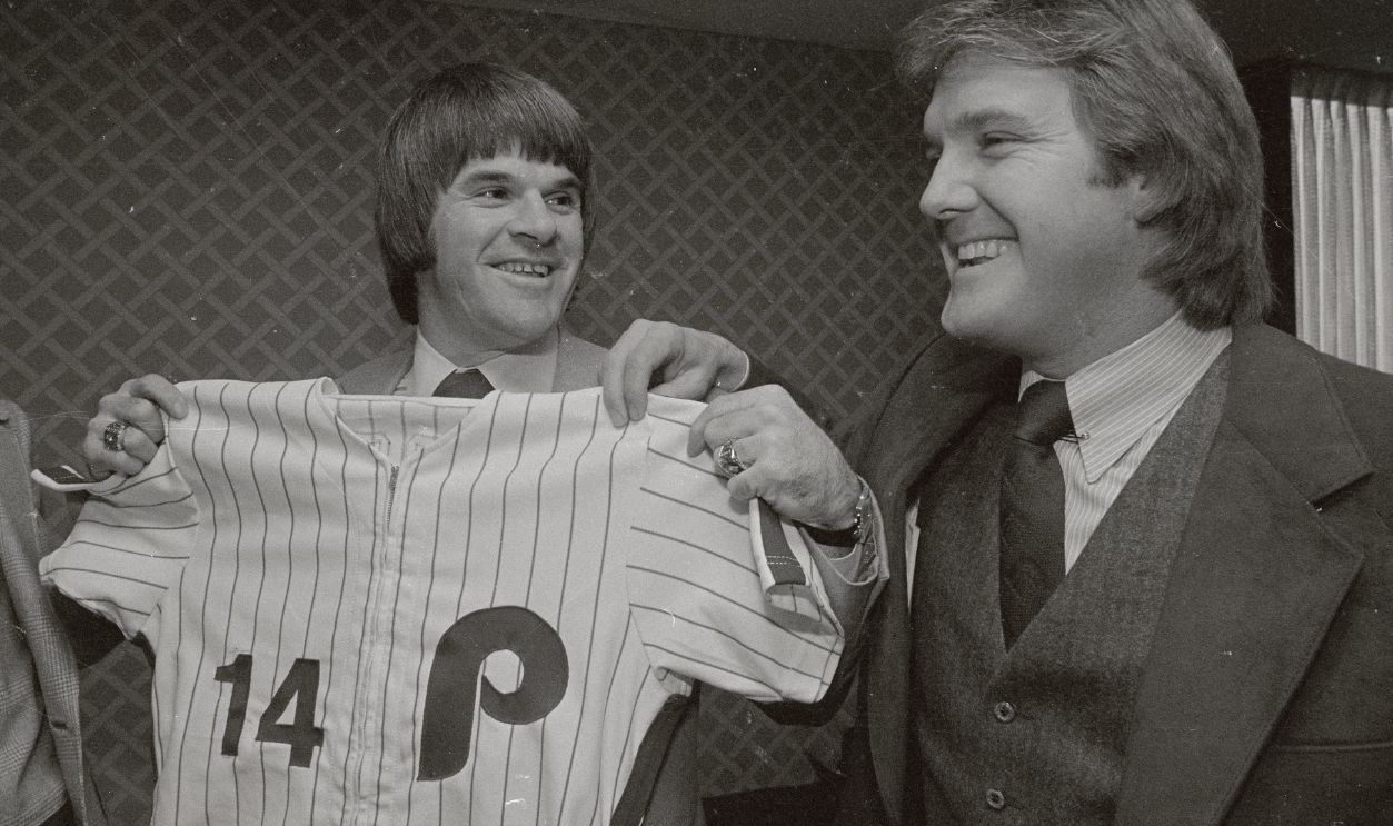 The newest Philadelphia Phillies, Pete Rose, looks over his new team shirt at a press meeting here in Philadelphia December 12th. This is Rose's first visit to Philadelphia since signing with the Phillies in the free-agent draft. Posing with Pete is Phillies pitcher, Tug McGraw.