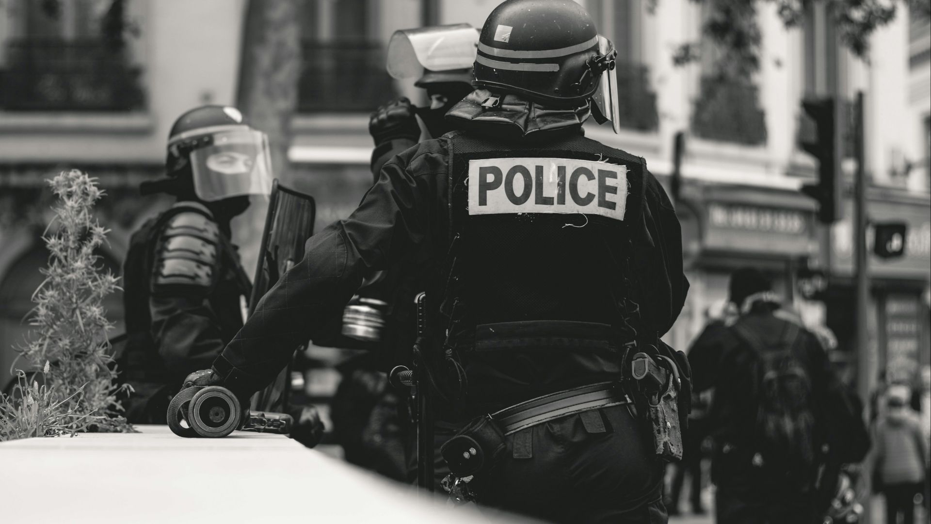 grayscale photo of Police standing and leaning on wall