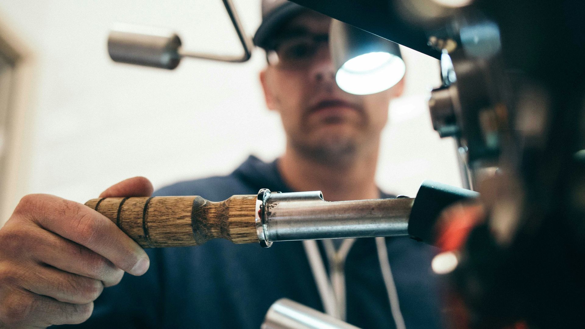 man wearing black pullover hoodie holding tool