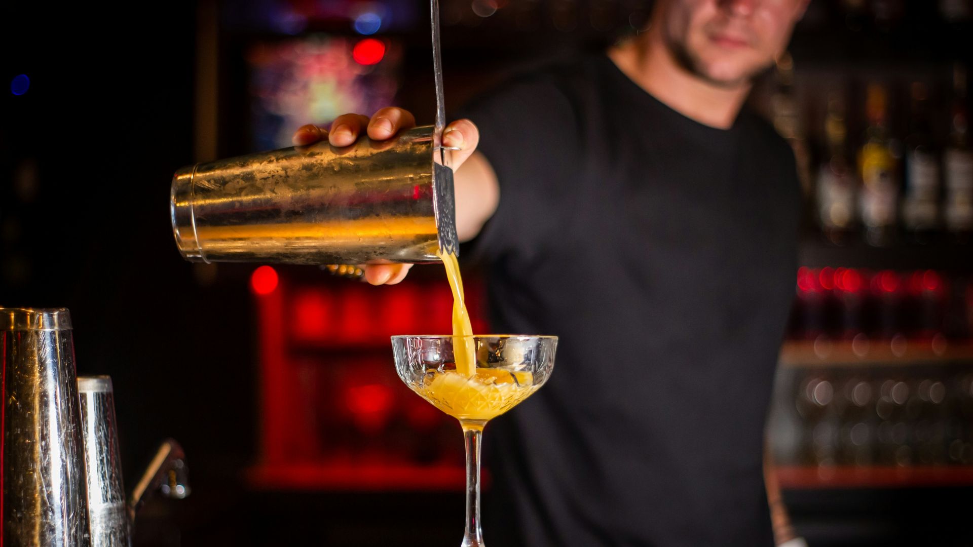 man in black crew neck shirt holding clear wine glass