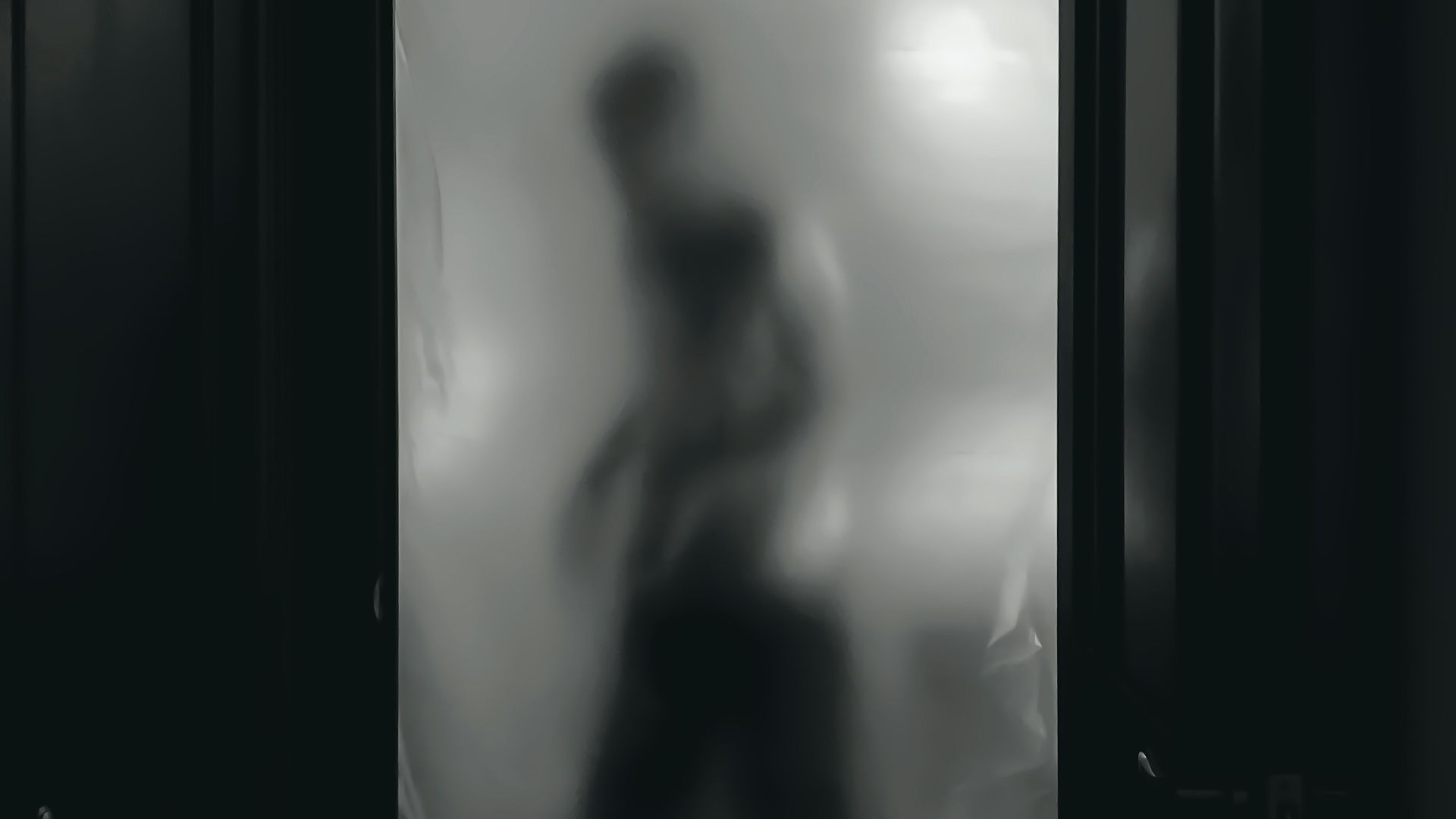 woman in black tank top standing in front of mirror