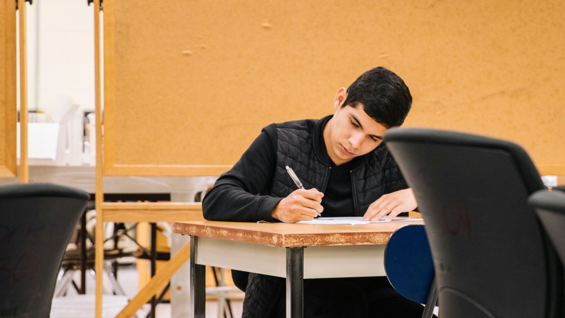 man in black long sleeve shirt sitting on black chair