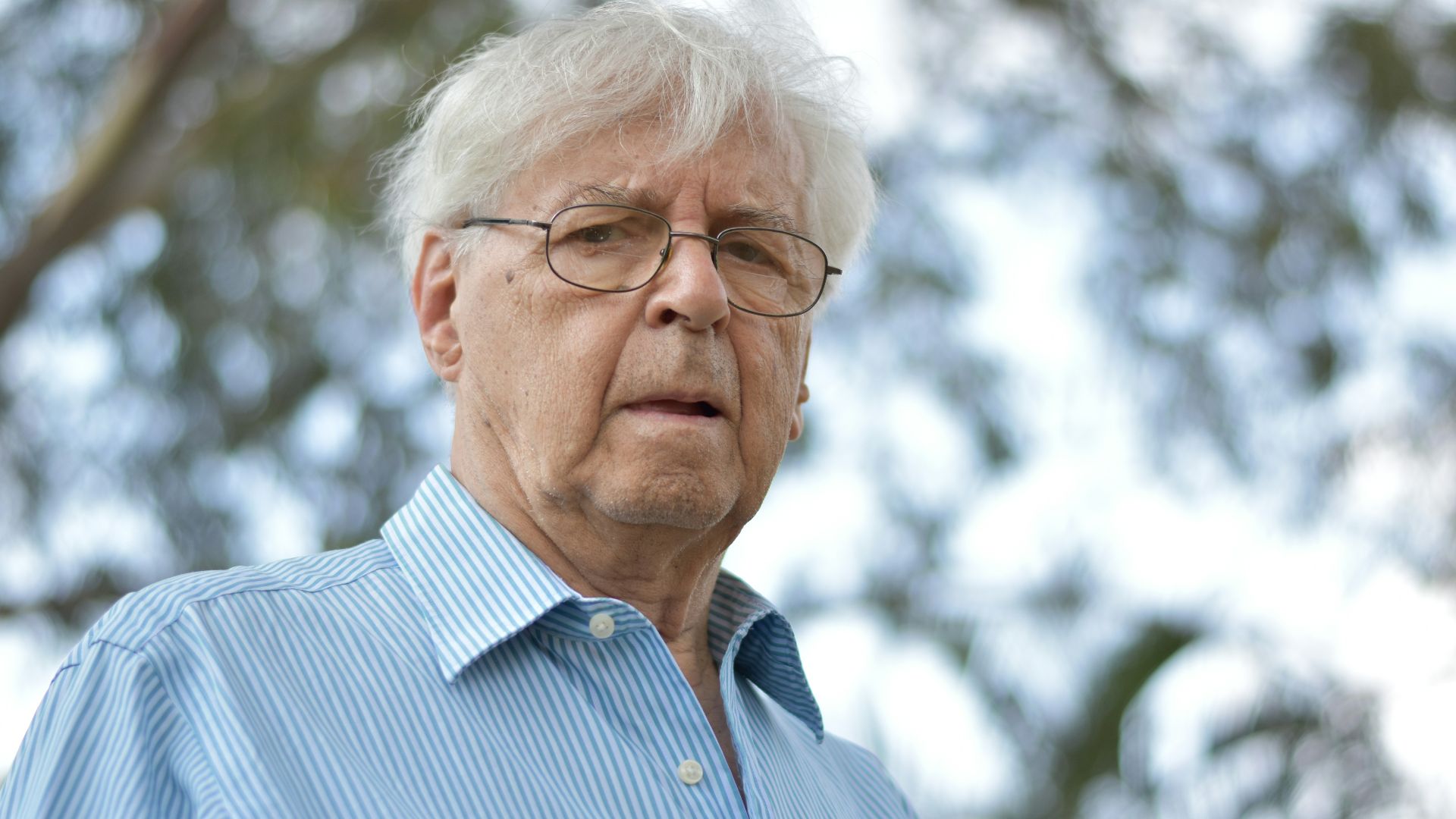 selective focus photography of man wearing blue and white striped collared top