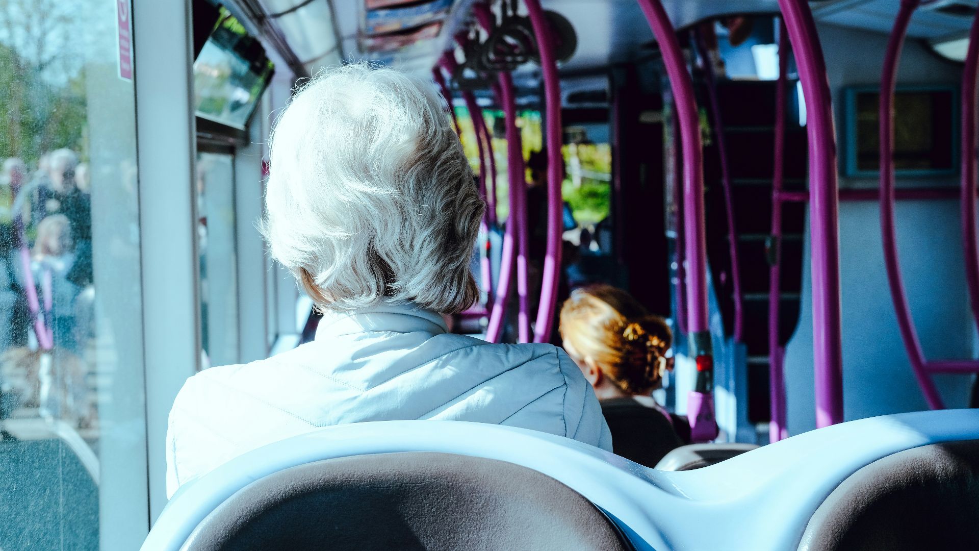 a woman sitting on a bus looking out the window